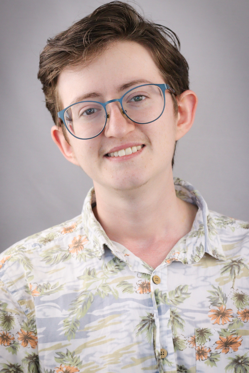 picture of Laurie, a smiling white guy with brown hair, glasses and a white and orange hawaiian shirt